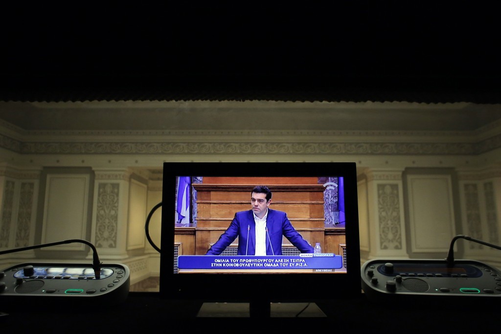 Greek Prime Minister Alexis Tsipras (on a TV screen).